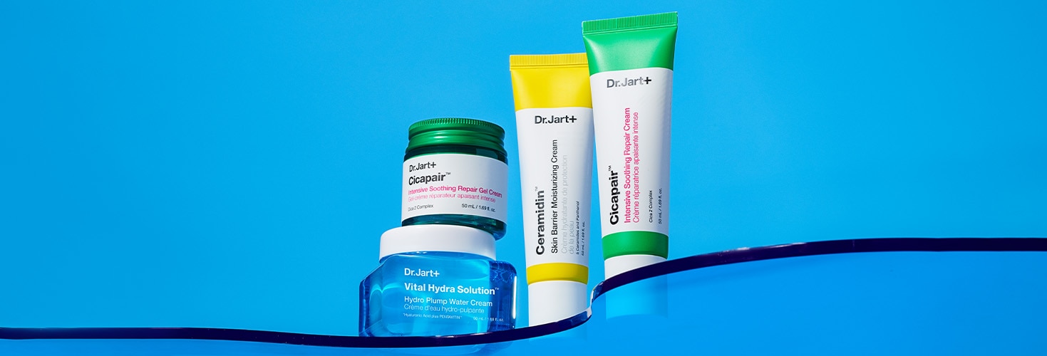 Jars and tubes of Dr.Jart+'s bestselling moisturizers stand tall in front of a bright blue backdrop