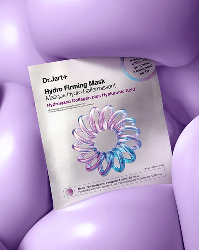 Woman smiles while applying a dollop of Ceramidin Moisturizer Cream to skin