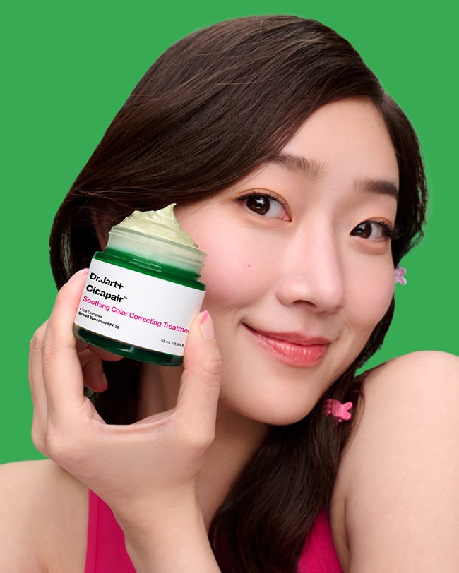 Green droplets of Centella leaves drop onto a ragged pink cube turning it smooth to show the change in irritated skin.