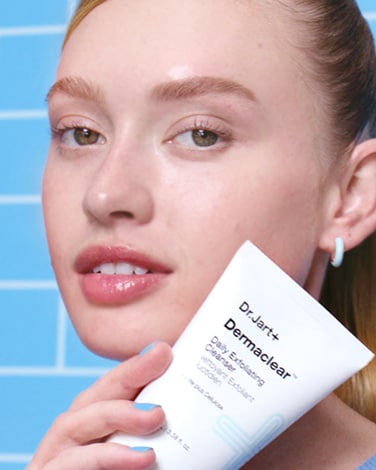 Two bottles of Premium BB Tinted Moisturizer are on a dark background showcasing the shade range thru the textures.