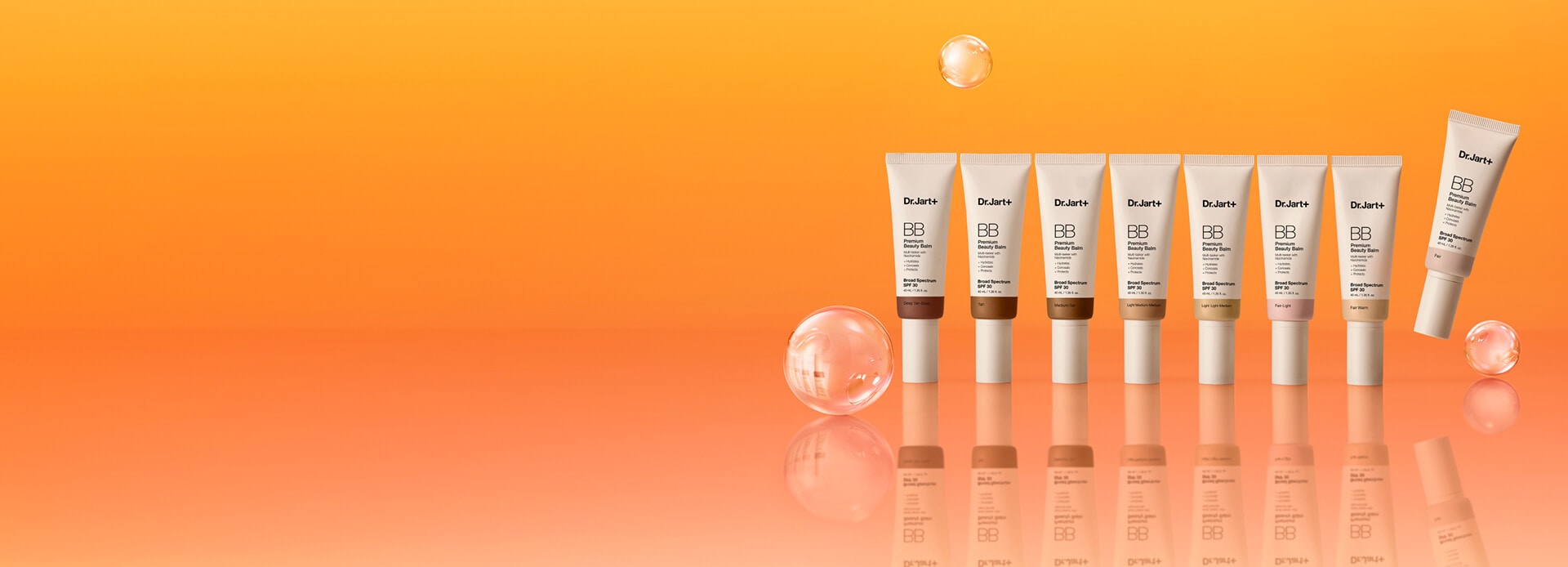 Premium BB Tinted moisturizer tubes in multiple shades are stacked on pink podiums in front of a bright pink backdrop.