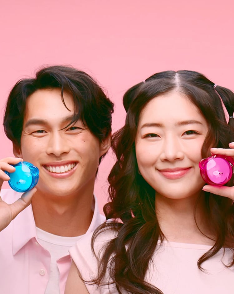 Boy & girl models hold up the pink and blue jelly lip mask packages. 