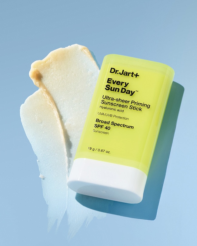Sunscreen stick is displayed on a blue background with the texture swooshed next to the package.