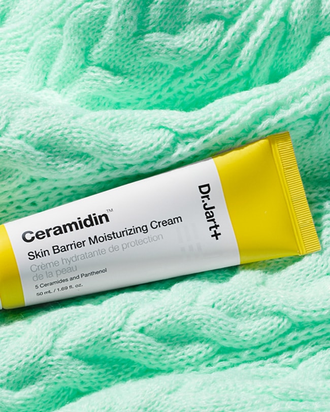 Ceramidin™ Skin Barrier Moisturizing Cream tube displayed on a green blanket