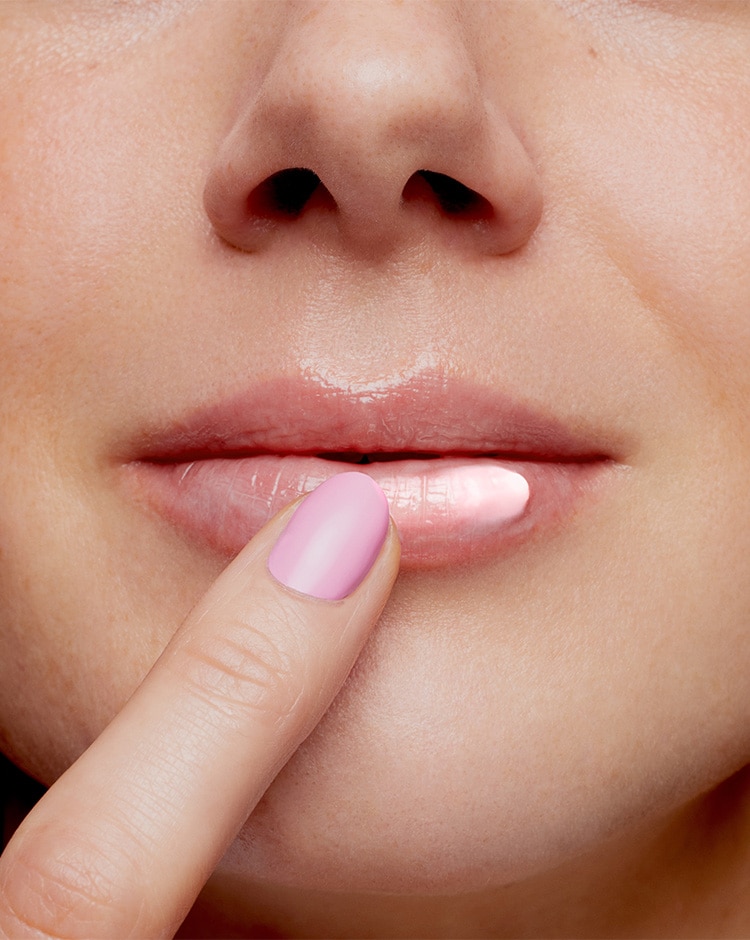 Model applies pink lip mask to her lips to show pink hue. 
