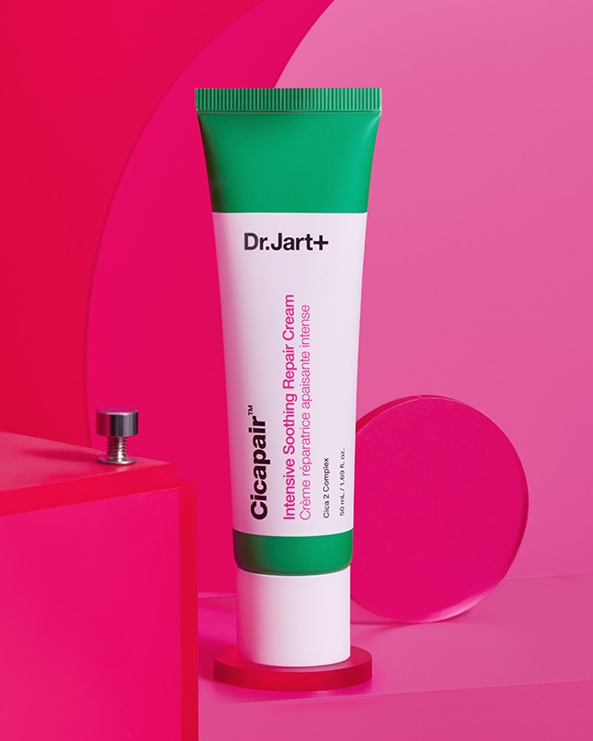 Tube of Cicapair Moisturizer Cream for sensitive skin balanced on artistic pink elements.