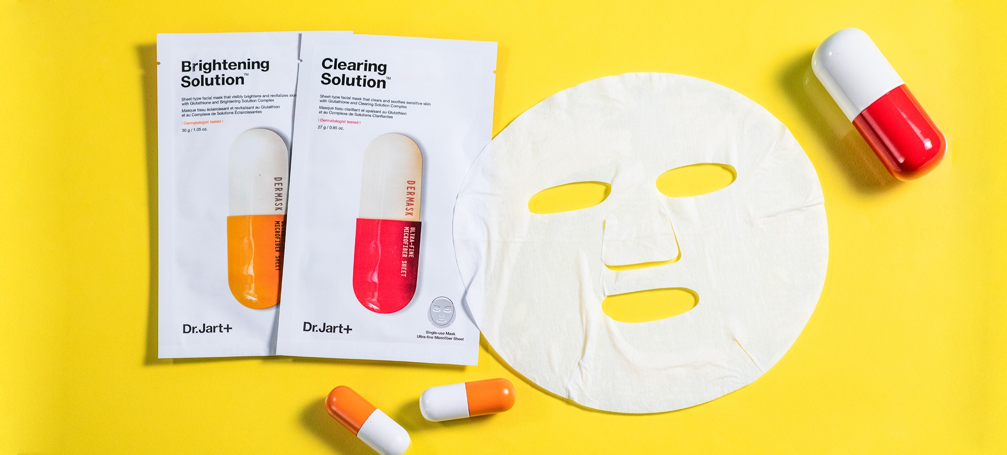 Dermask brightening and clearing masks laid on a bright background with decorative pill capsules
